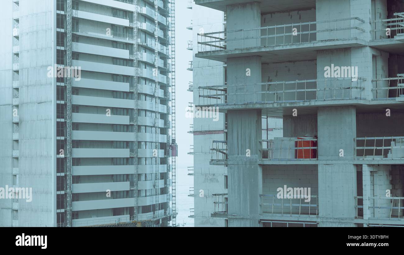 Two high-rise buildings in various stages of construction with ...