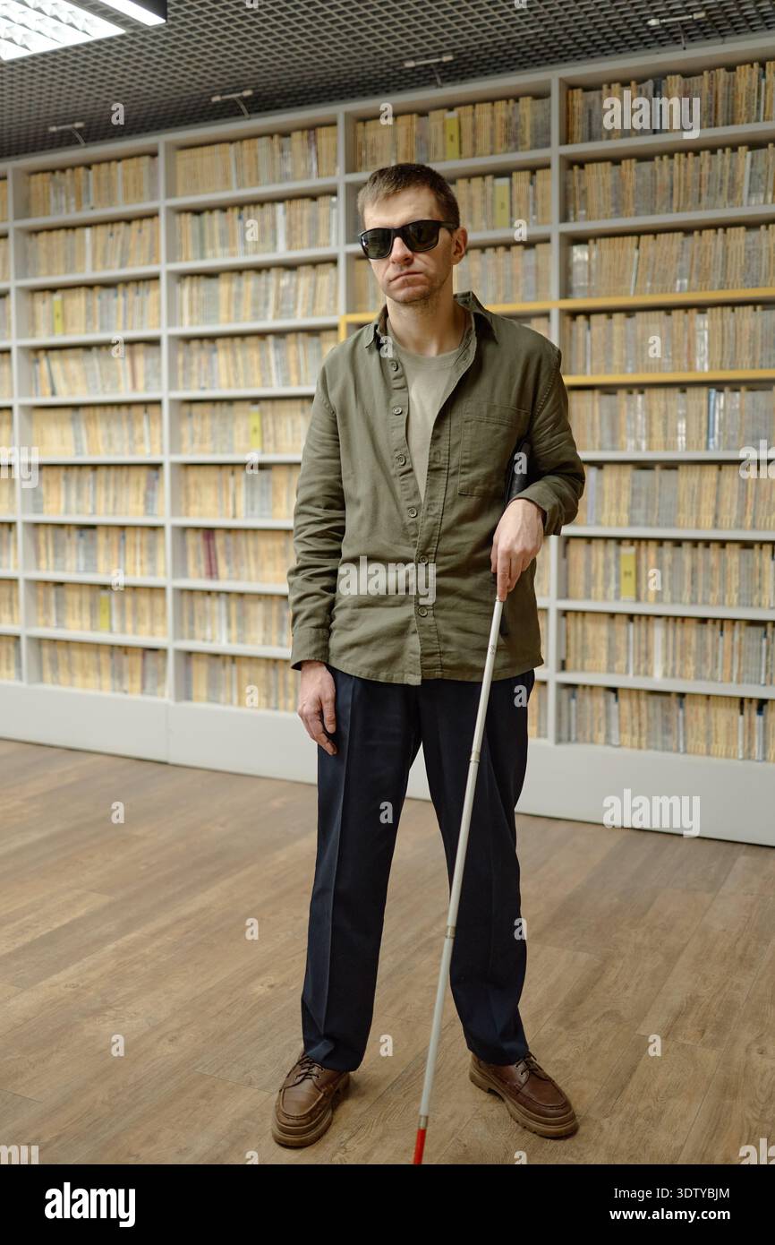 Middle Aged Blind Man Using Cane Navigating Library Stock Photo