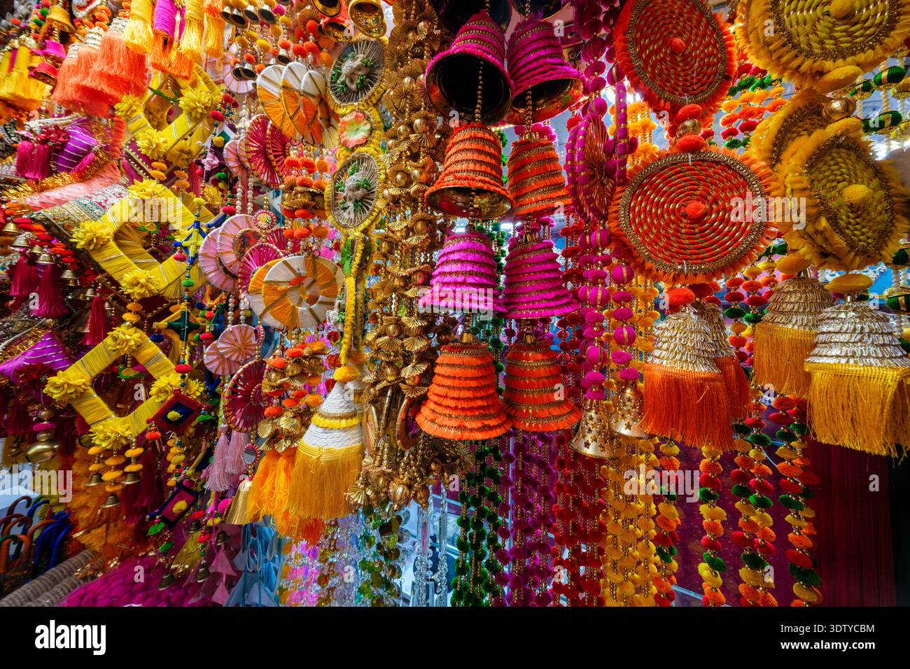 A vibrant display of traditional colourful decorative hangings, tassels and bells for sale at Kinari Bazar, Old Delhi. Stock Photo