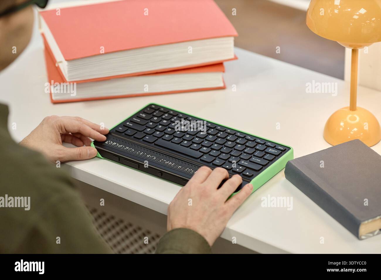 Middle Aged Man Using Braille Keyboard While Studying in Library Stock Photo
