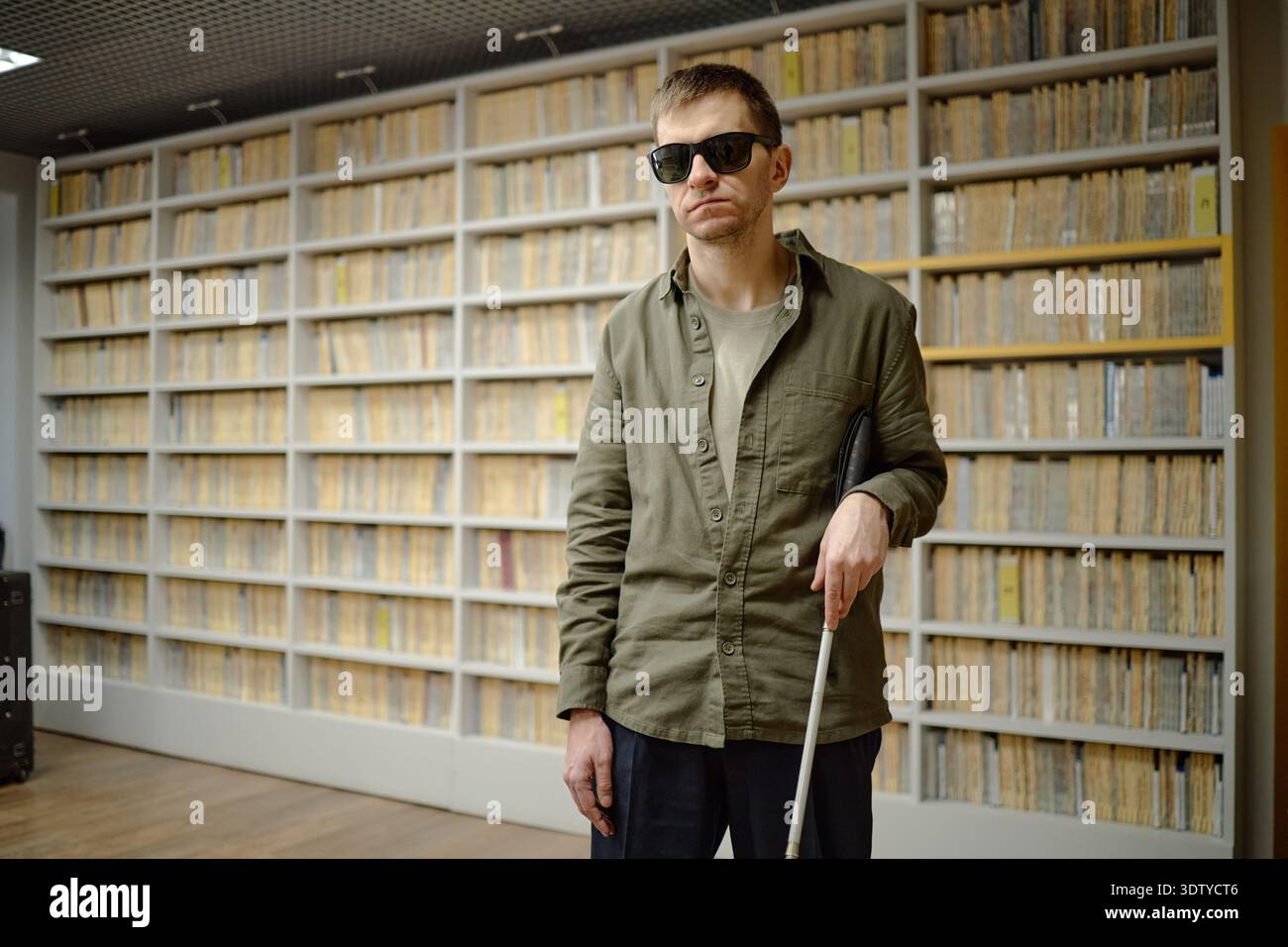 Middle Aged Man Using Cane Navigating Library While Blind Stock Photo