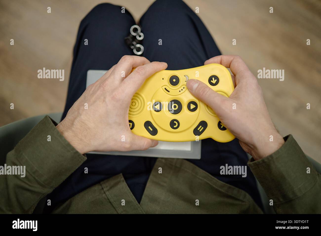 Blind Man Using Adaptive Electronic Controller While Sitting in Library Stock Photo