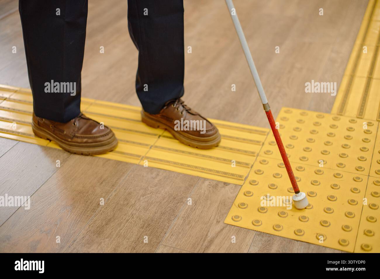 Middle Aged Man Navigating Library Floor Using Cane for Blind Stock Photo