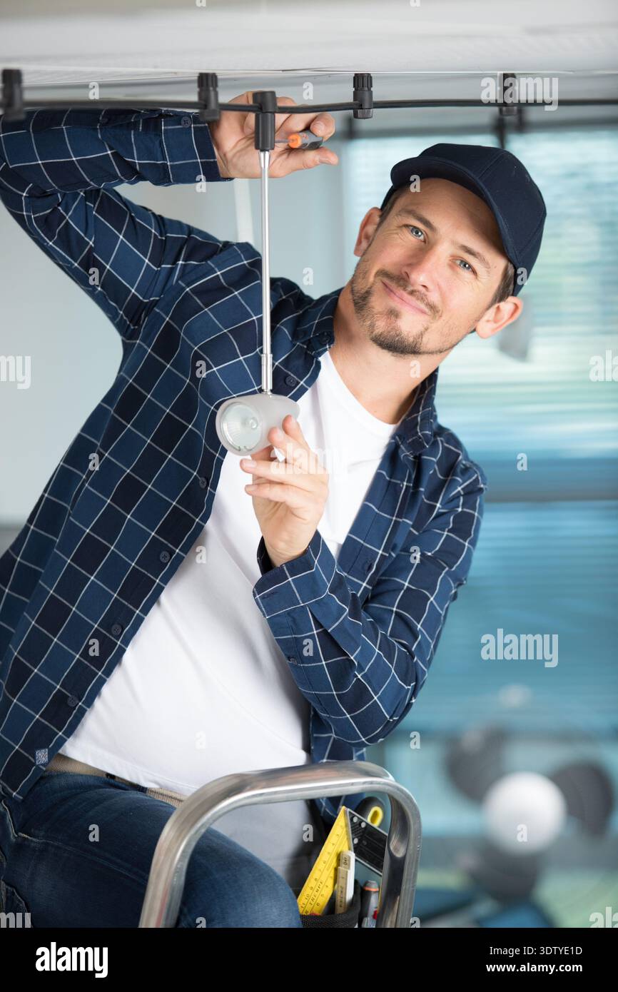 young guy repairs a light ceiling Stock Photo