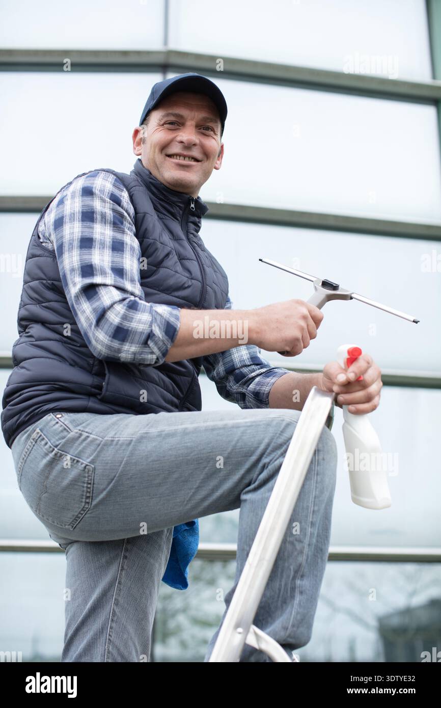male cleaner washes windows and store front Stock Photo