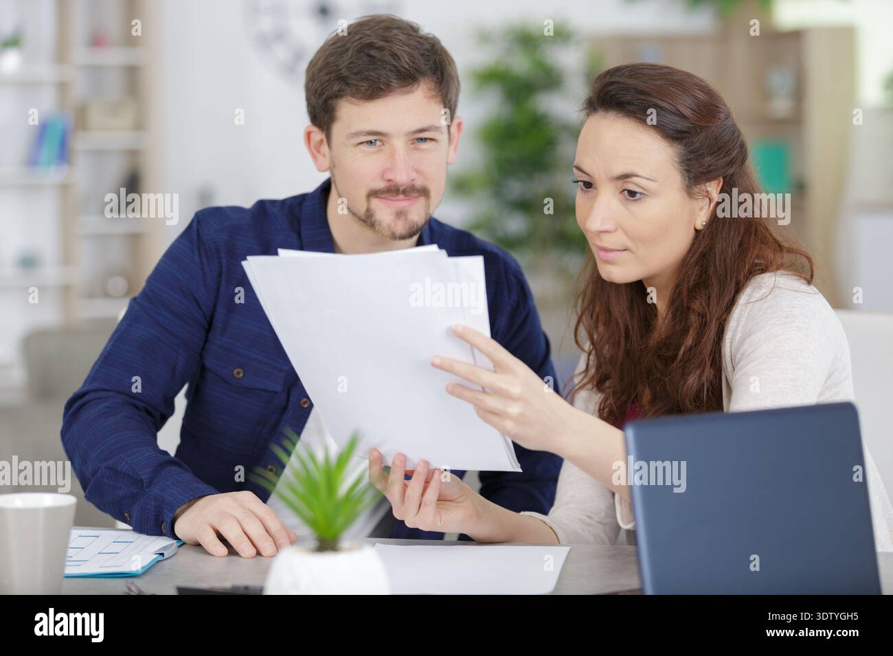couple holding reading financial documents checking paying household bills Stock Photo