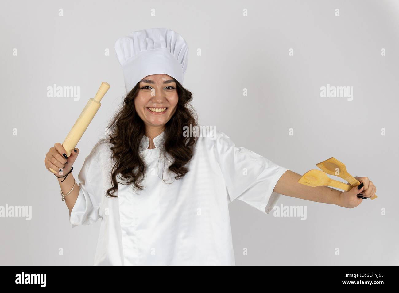 Smiling female chef holding rolling pin and dough Stock Photo