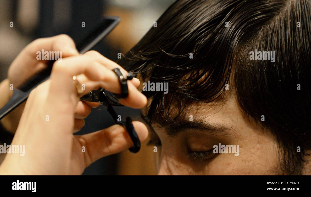 Barber hands using scissors for precise haircutting process Stock Photo