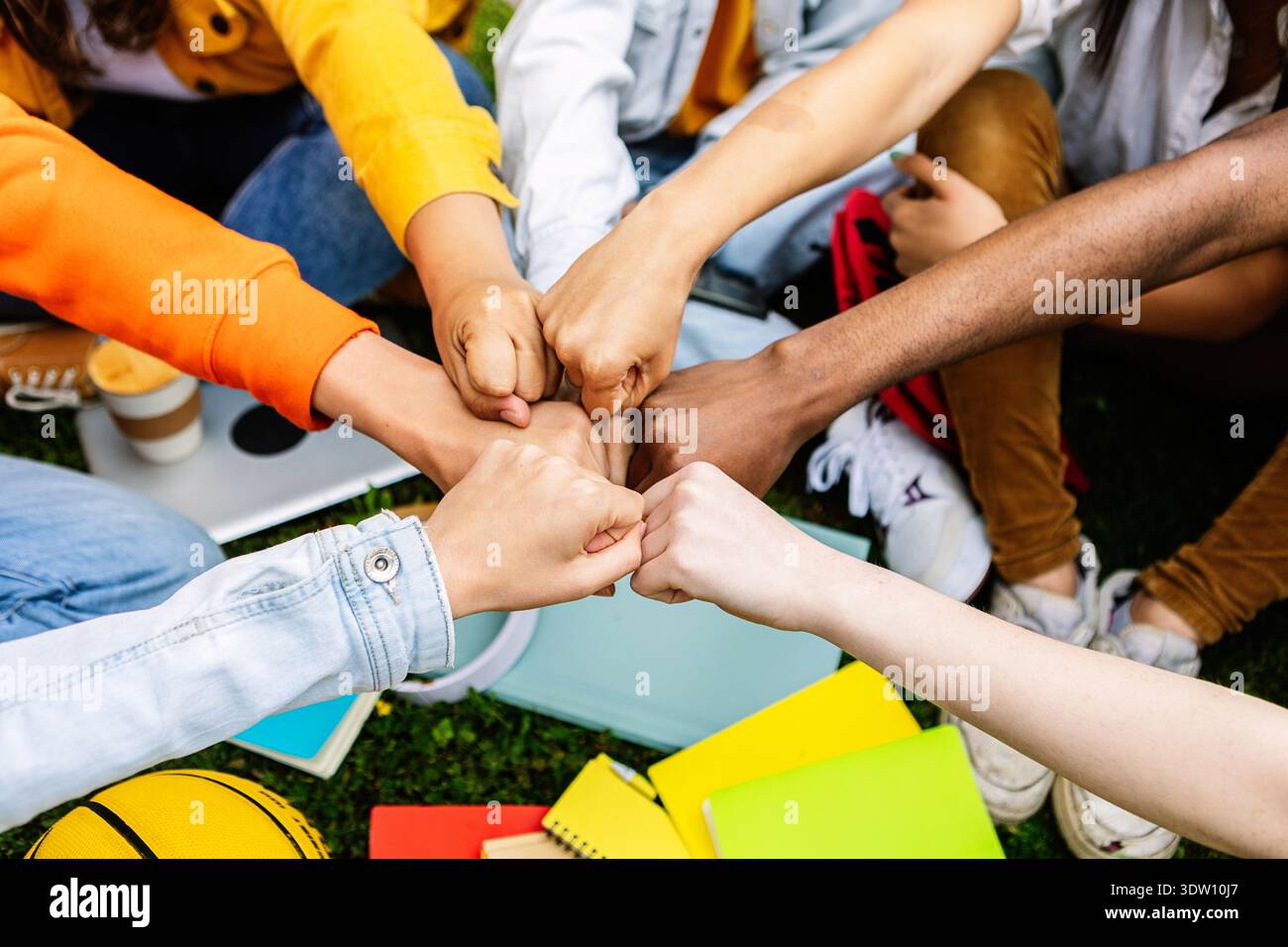 Young group of teenage students joining hands showing support and cooperation Stock Photo
