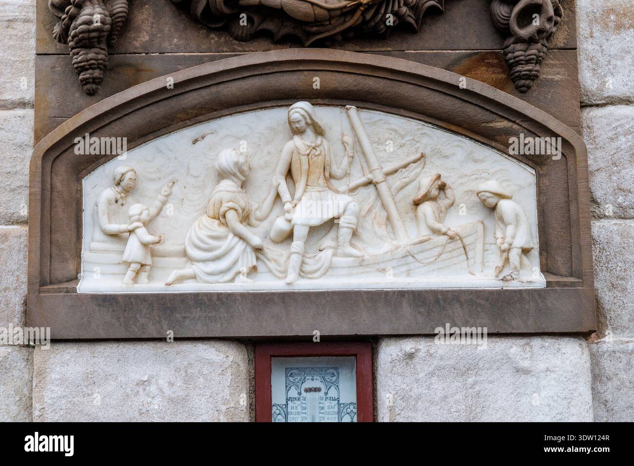 Relief of a fisherman leaving shore with a pleading wife on the Fishermen's Monument with a Barometer for boats installation on the harbout quay, Dunb Stock Photo
