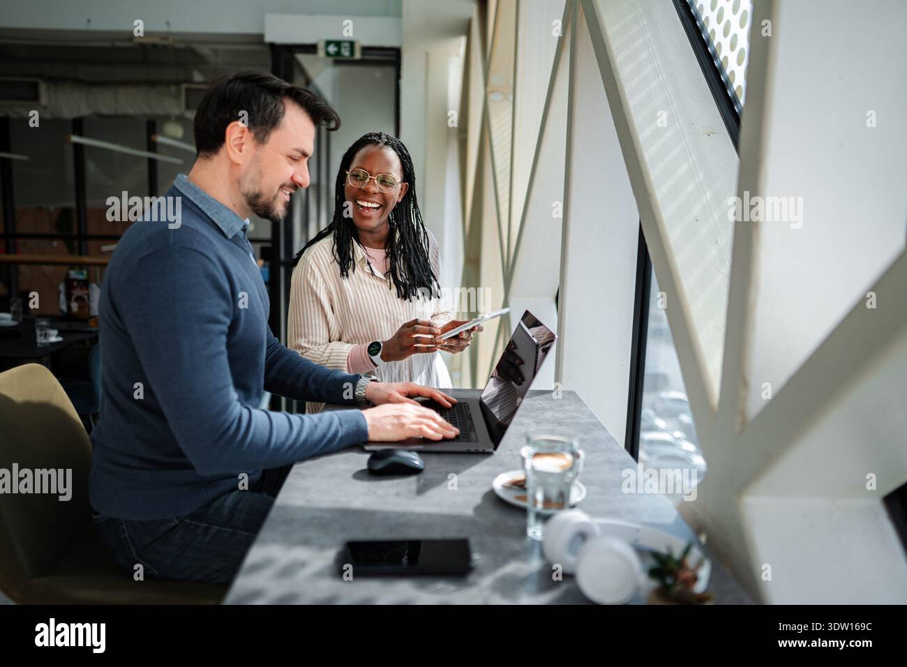 Coworkers collaborating remotely laughing while discussing business ideas Stock Photo