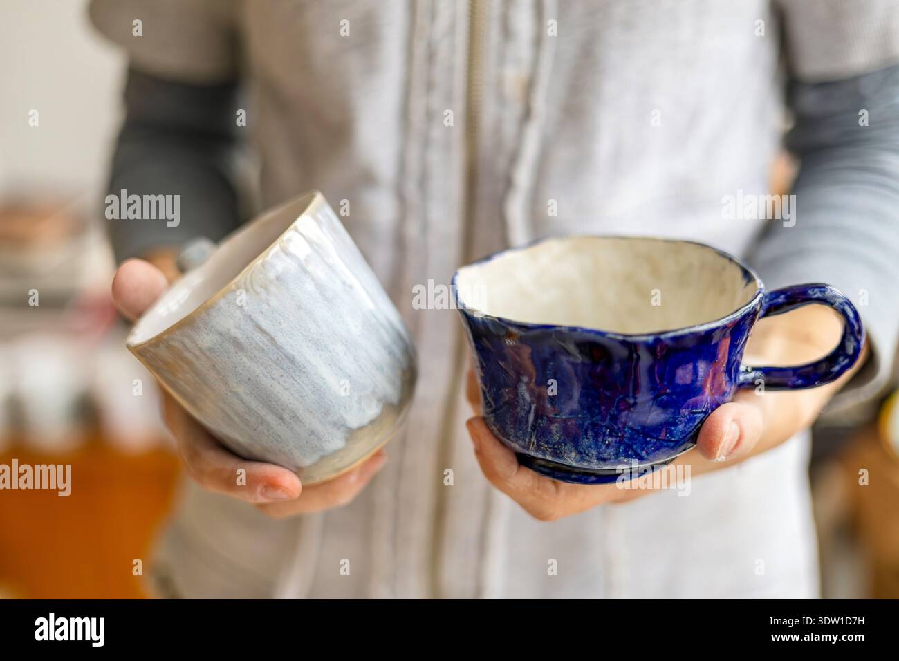 Woman's hands holding two handmade cups, close-up Stock Photo