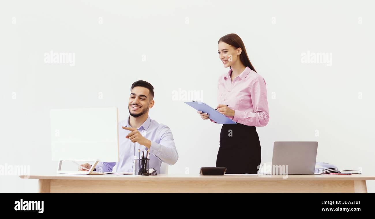 Team Members Discuss Project Progress in an Office Setting During Daytime Hours Stock Photo