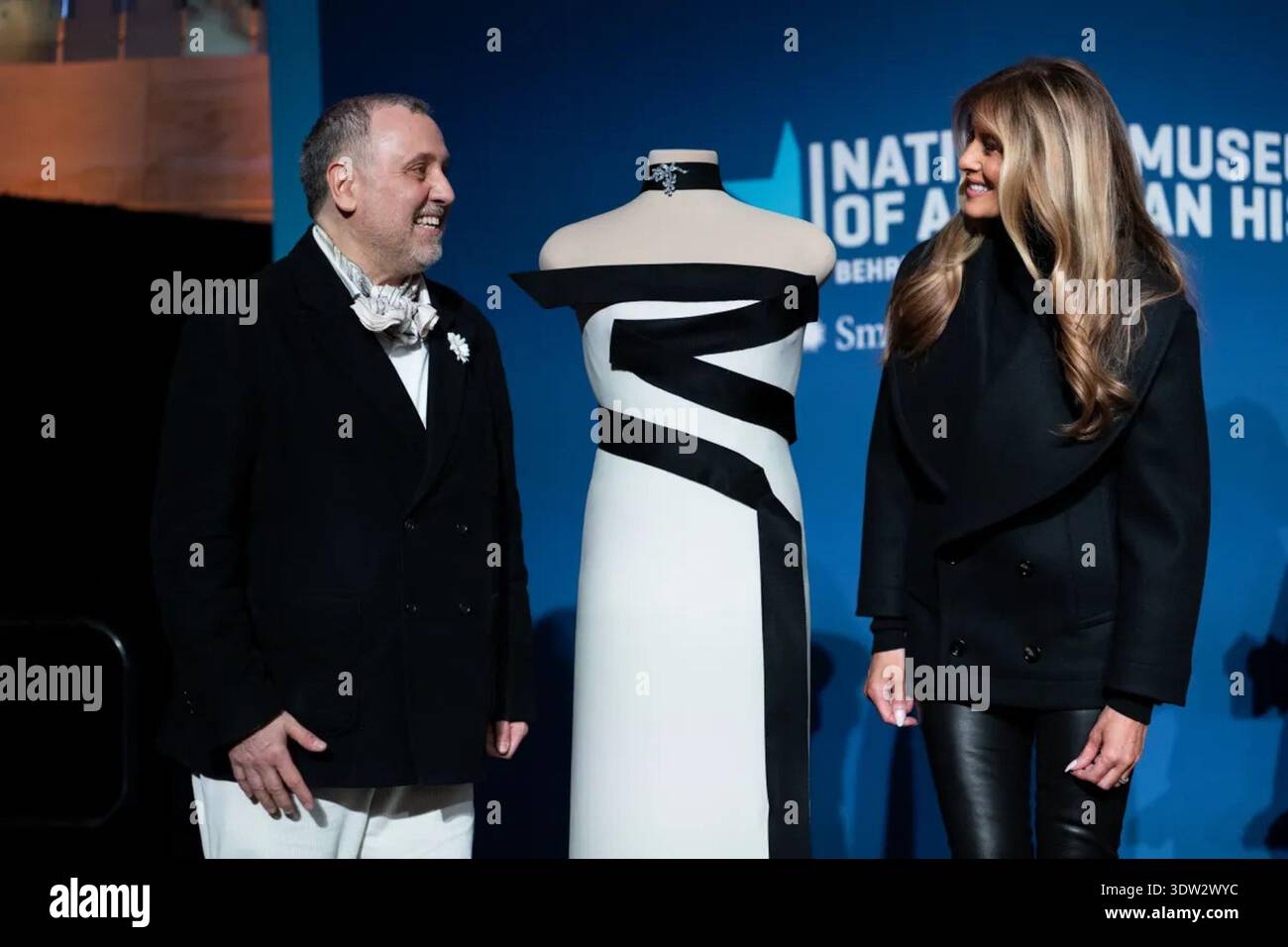 First Lady Melania Trump and designer Herv Pierre stand beside the 2025  inaugural gown during its presentation to the First Ladies Collection at  the Smithsonian National Museum of American History in Washington,