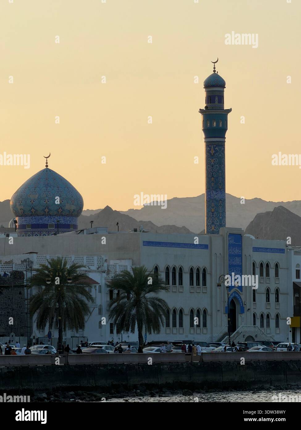 Illuminated mosque with crescent moon symbol at dusk in Muscat, Oman - Smartphone Captured Stock Image