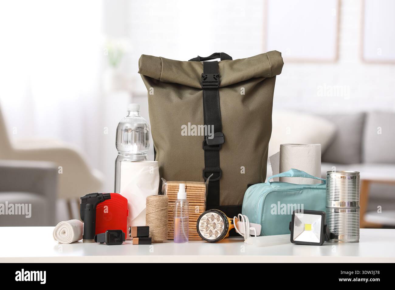 Emergency backpack and necessities on table at home Stock Photo