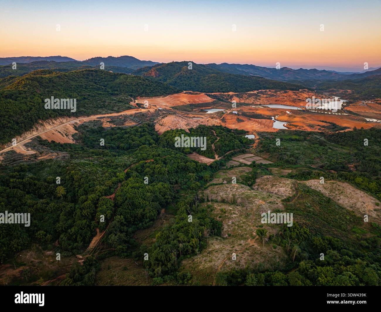 Drone shot of Tad Ma Waterfall flowing through a productive agricultural landscape with rice paddies, livestock farms, and well-irrigated fields in Vi Stock Photo