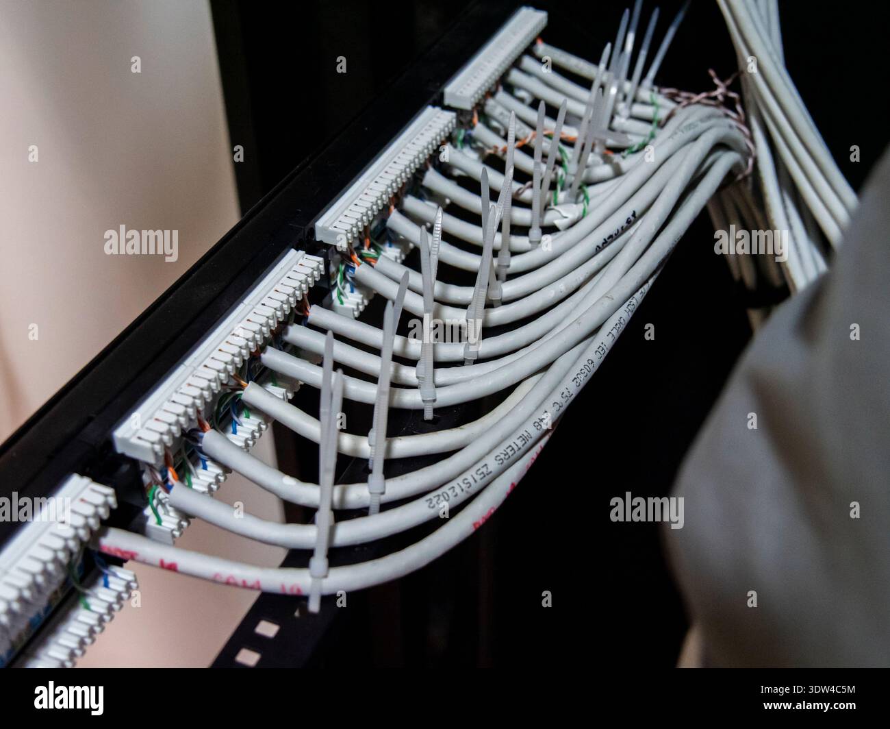 Technician hands installing network cables in server rack Stock Photo