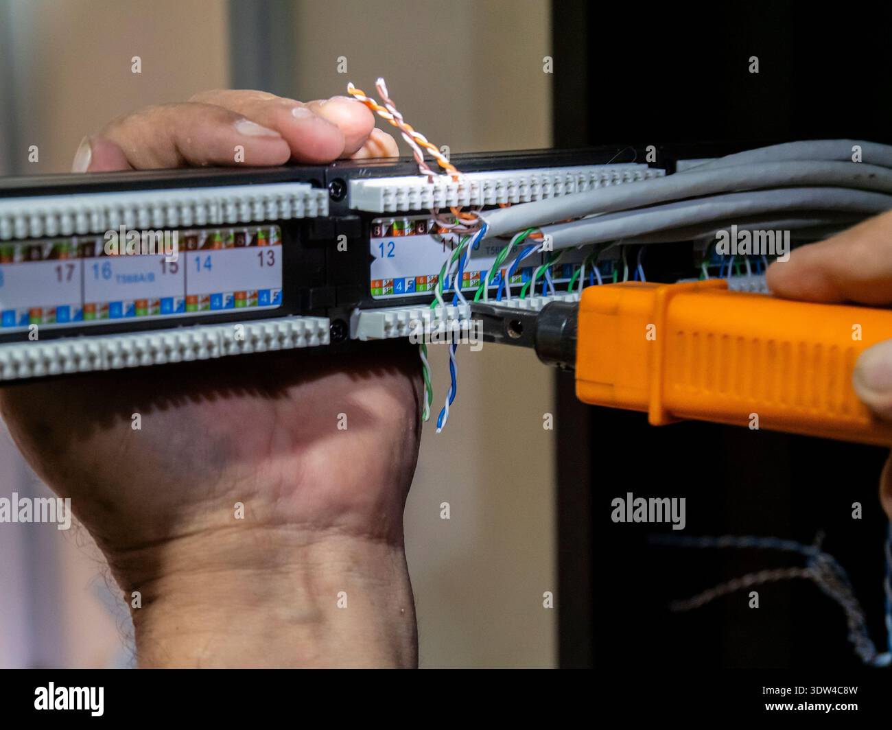 Technician hands installing network cables in server rack Stock Photo