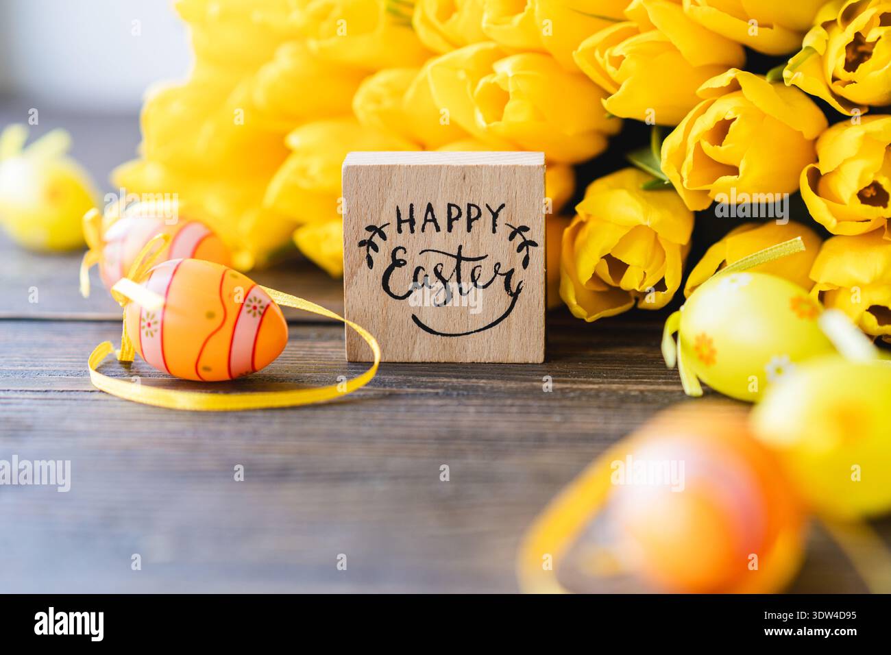 Spring festive composition with yellow tulips and decorative eggs Stock Photo