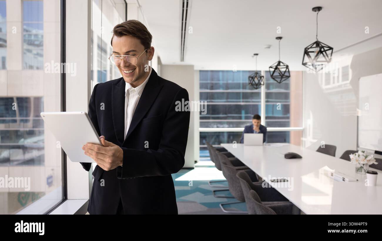 Confident young businessman smiling while working on digital tablet Stock Photo