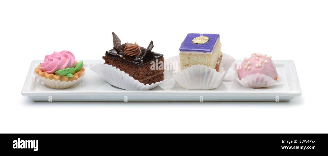 Four different mini cakes on ceramic plate isolated on white Stock Photo