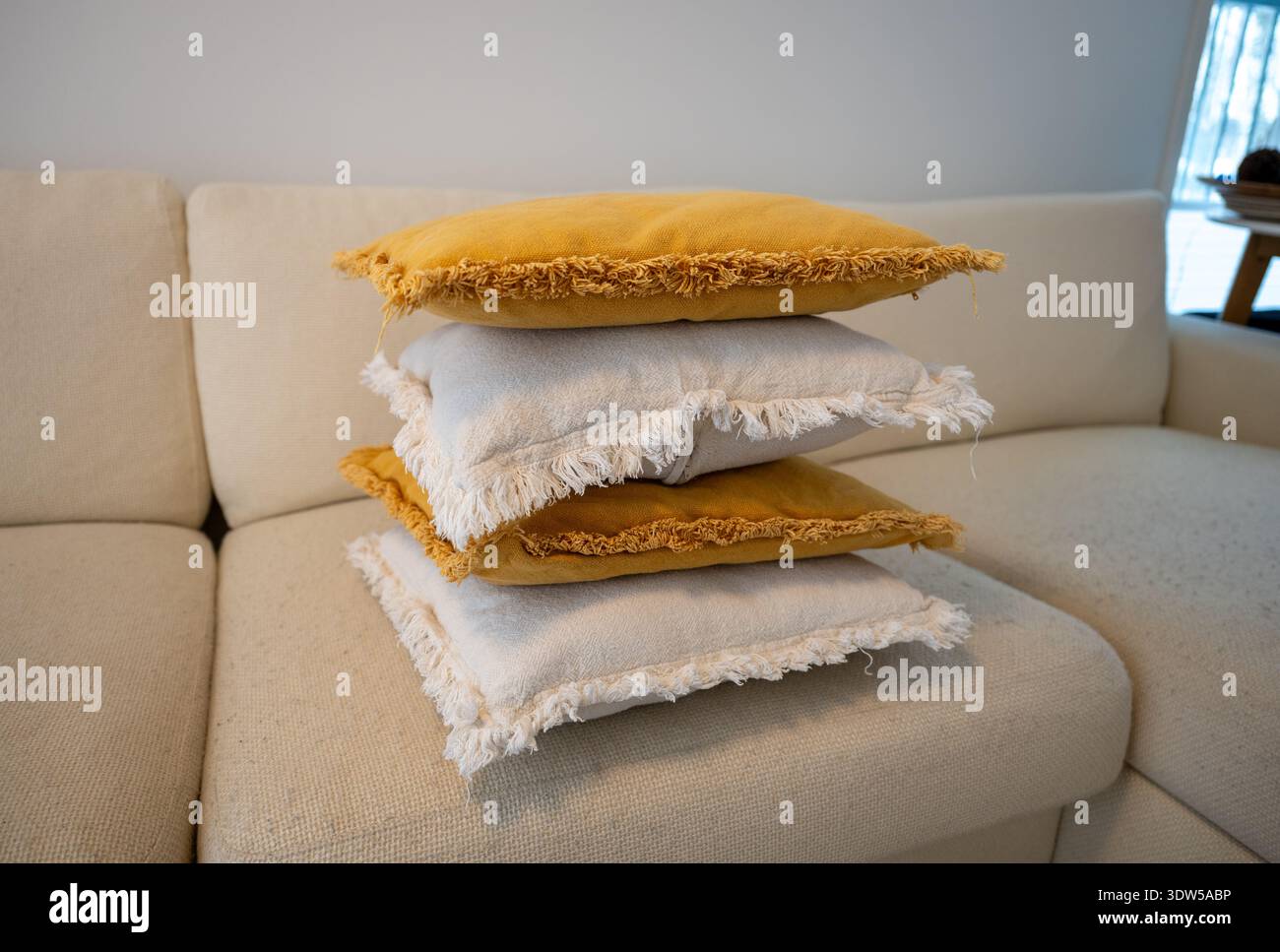 Stack of decorative pillows on sofa in cozy Scandinavian living room Stock Photo