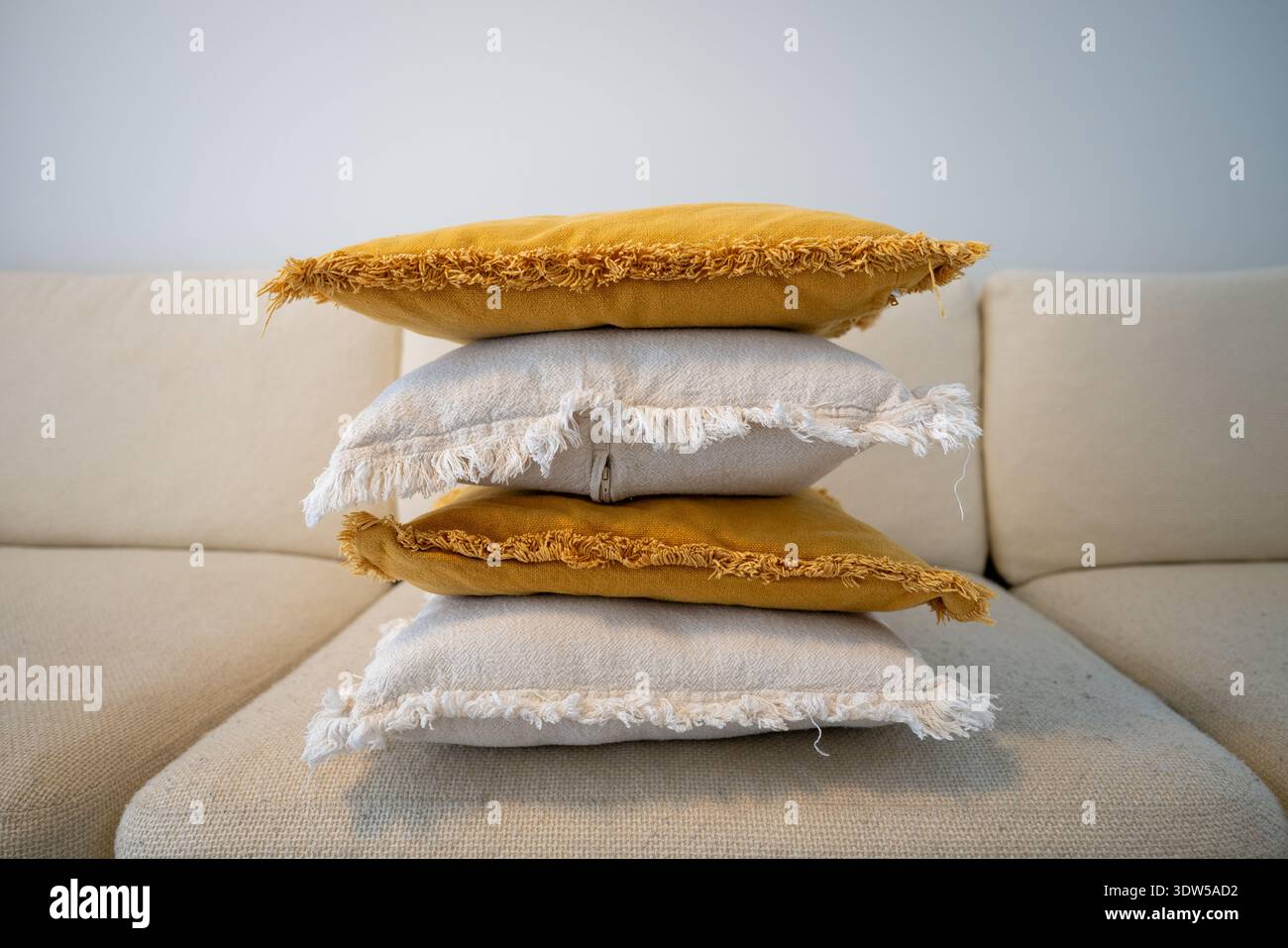 Stack of decorative pillows on sofa in cozy Scandinavian living room Stock Photo