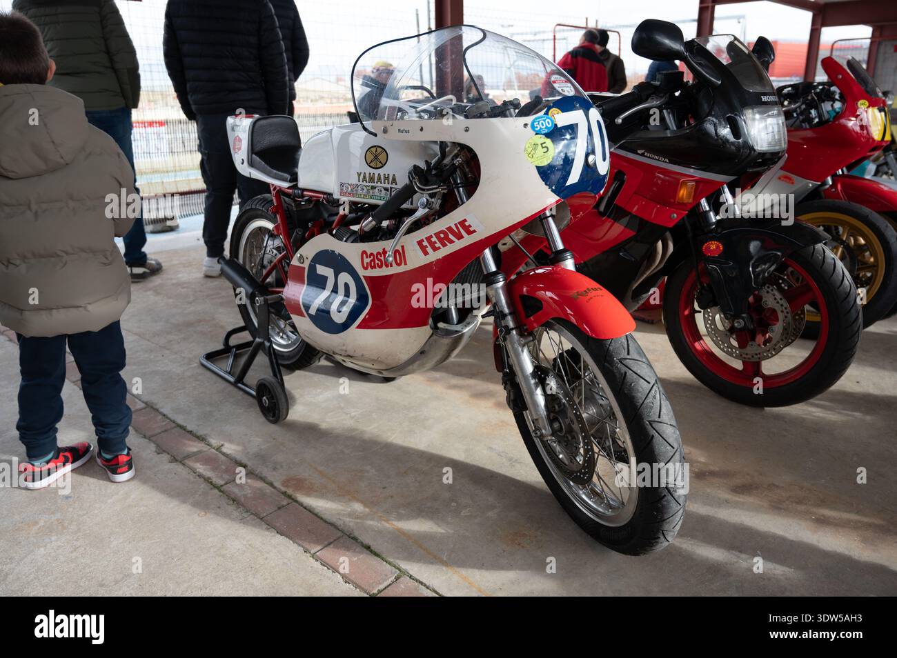 Side view of a vintage white and red Yamaha TZ racing motorcycle