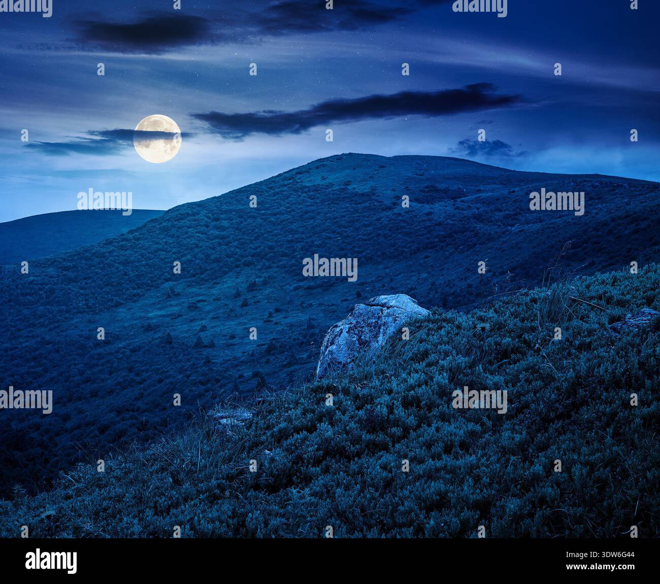 mountain landscape during summer at night. alpine meadows on green slopes and hills in full moon light. amazing adventure scenery. mysterious explorat Stock Photo