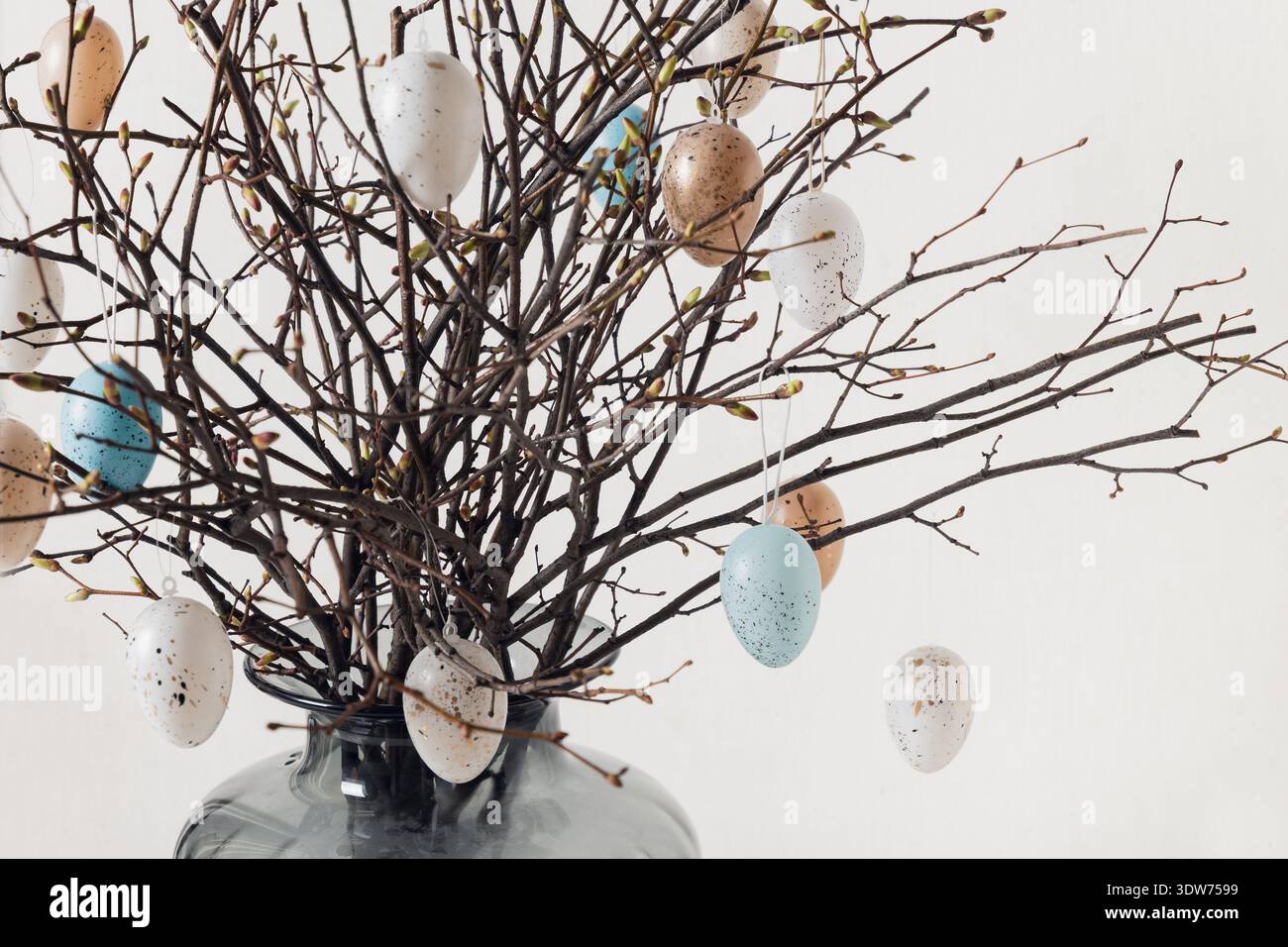 Pastel Easter eggs on decorative spring tree branches Stock Photo