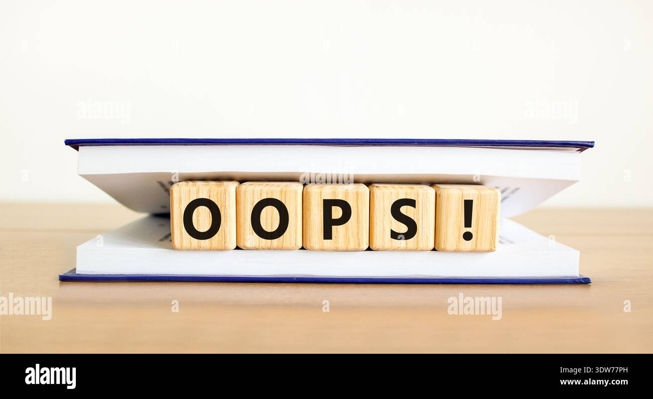 Oops symbol. Concept word Oops on beautiful wooden blocks in book. Beautiful wooden table white background. Business lifestyle oops concept. Copy spac Stock Photo