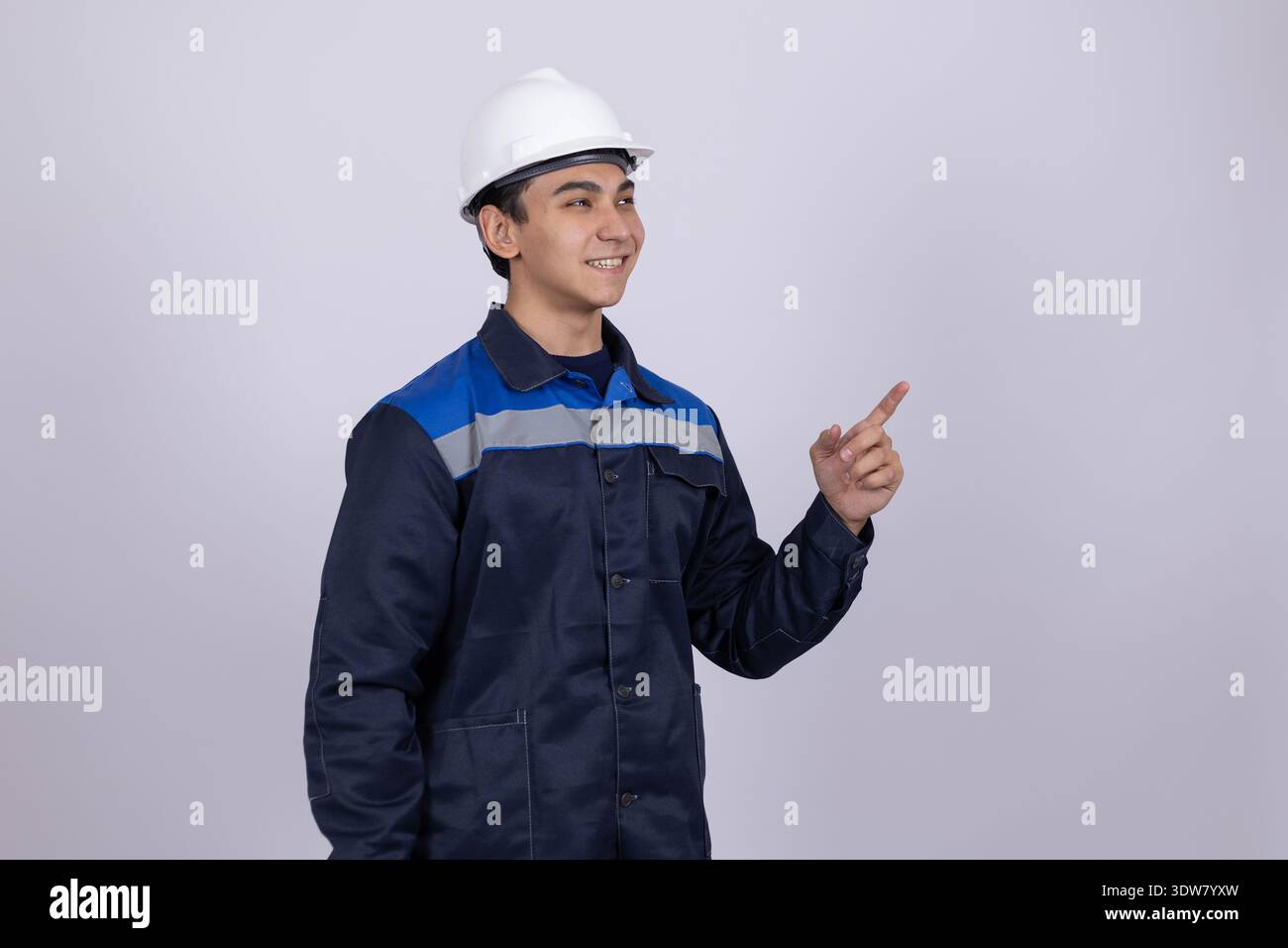 Construction worker pointing aside and looking at camera Stock Photo
