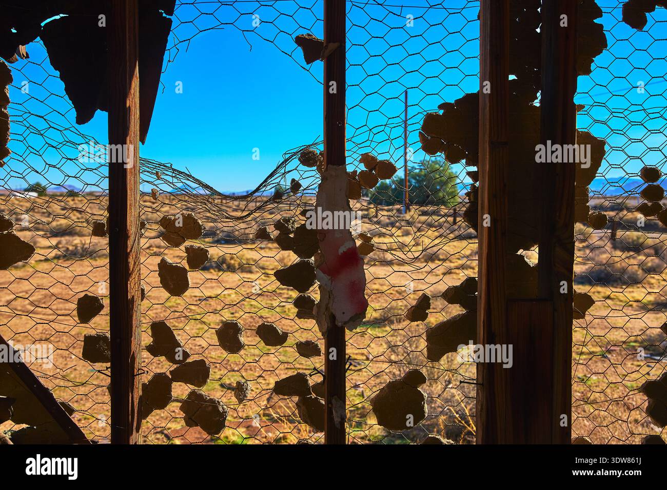 Abandoned Chicken Wire Fence and Broken Plaster Frame in California Desert Ruin Stock Photo