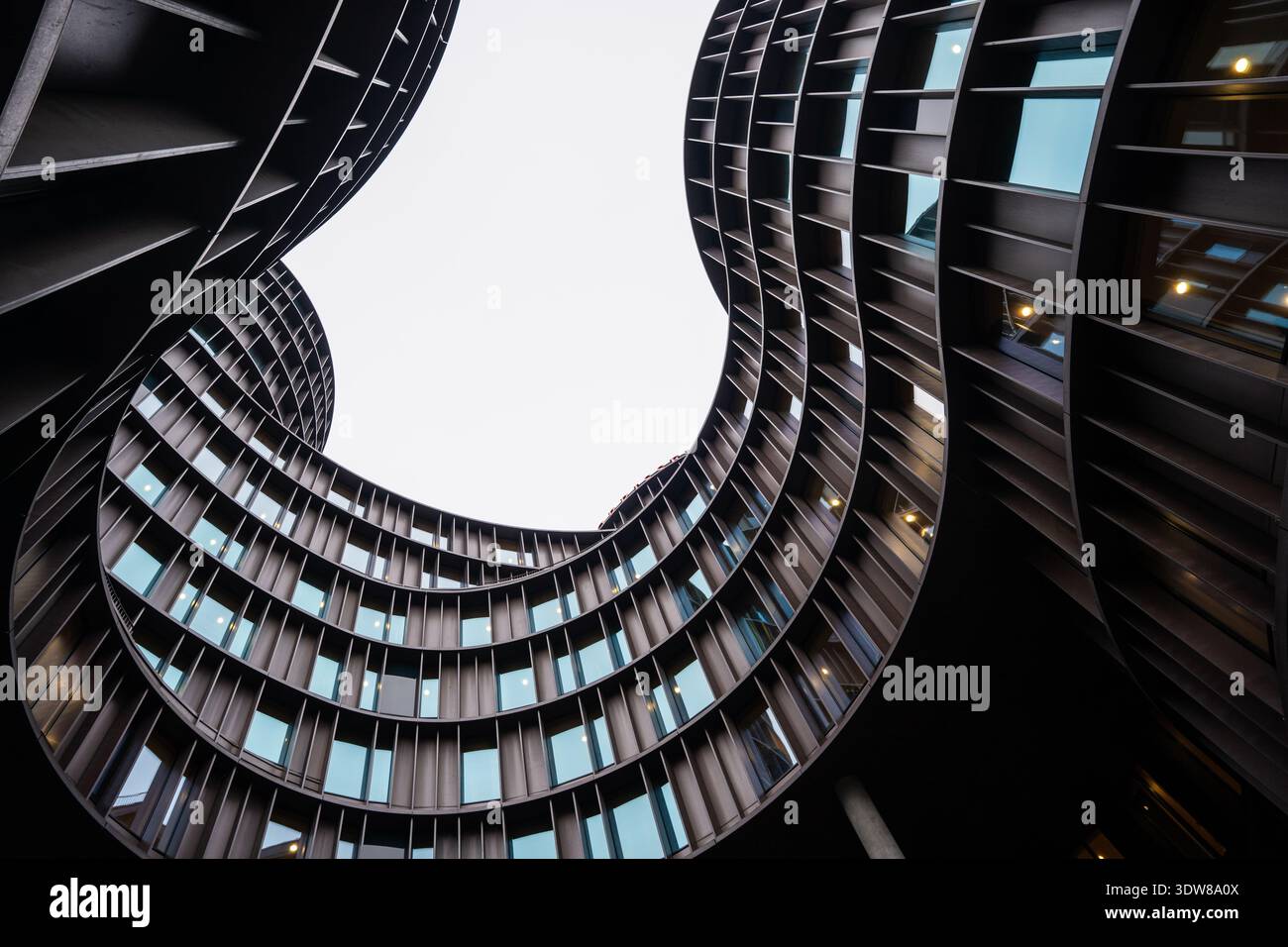 Modern curved apartment building viewed from below with dramatic ...