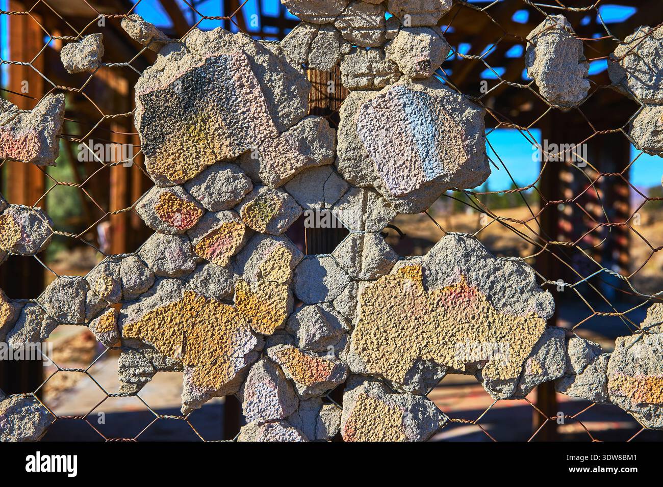 Abandoned Concrete Wall Texture and Wire Mesh in Sunlit Desert Structure Stock Photo