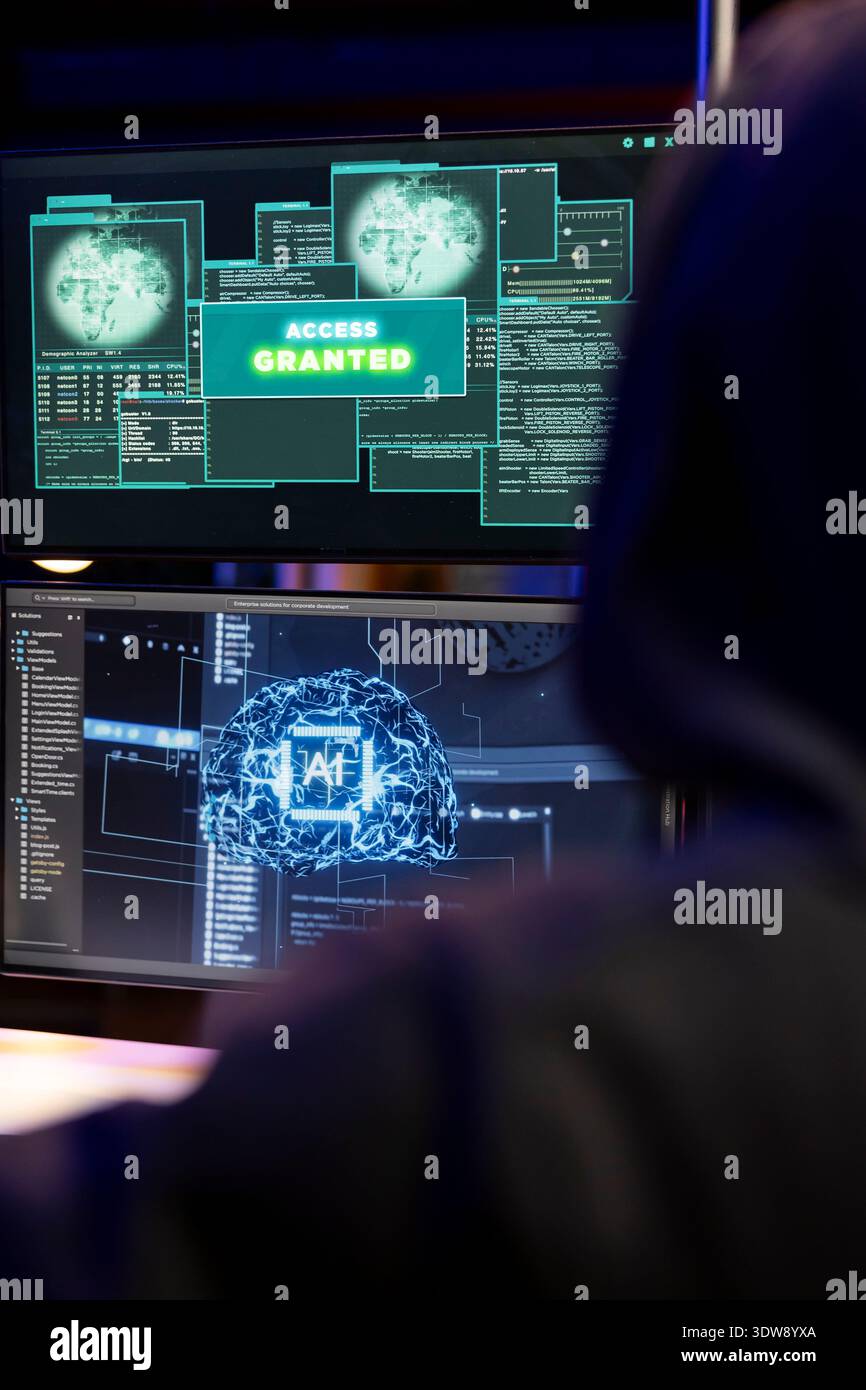 Cybercriminal coding on PC getting access granted message, evading security with stealth malware. Evil man successfully making script hiding malicious code from detection systems Stock Photo