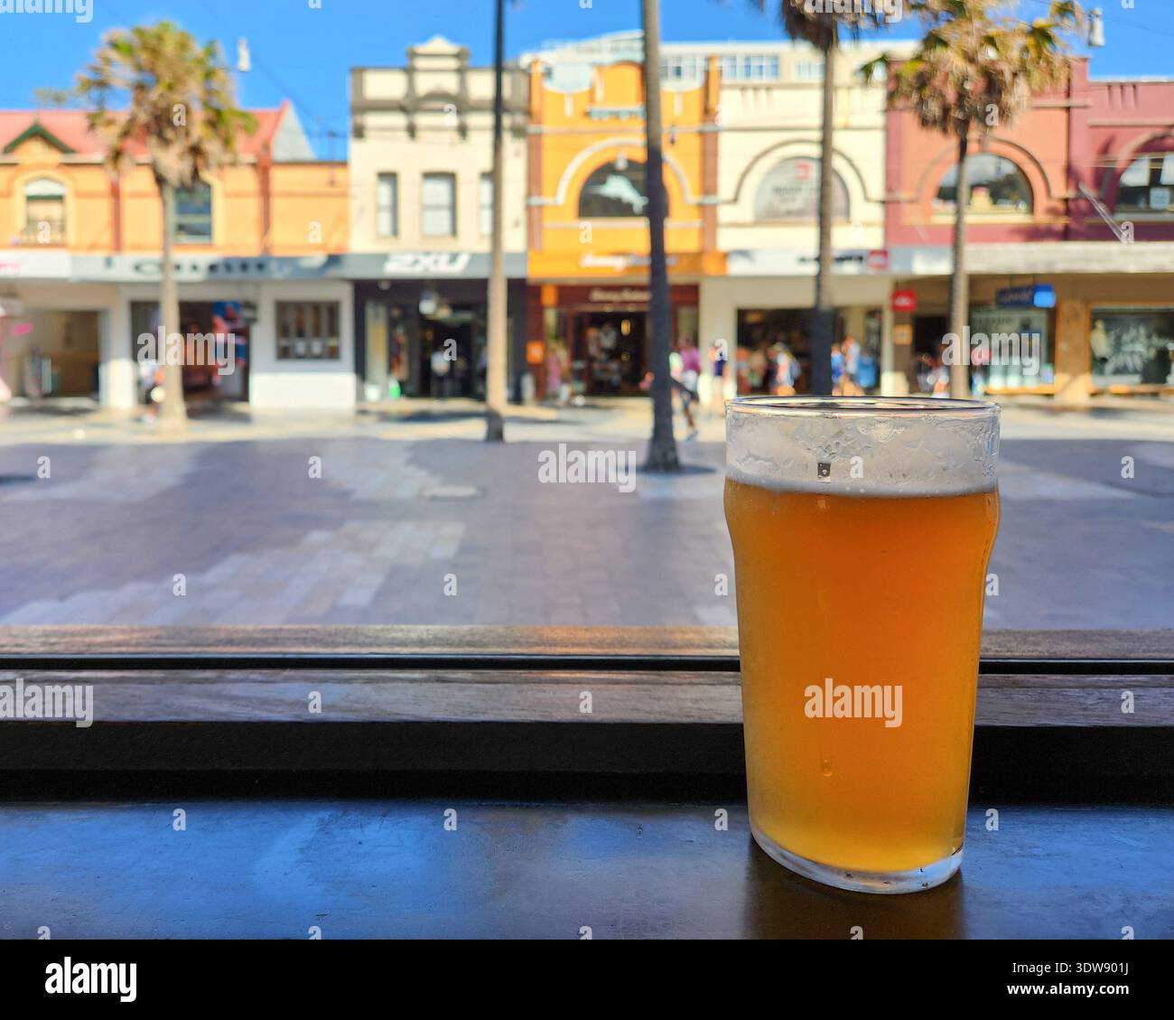 A pint of beer on a window sill with the Manyl Corso in the background on a summer afternoon - Smartphone Captured Stock Image