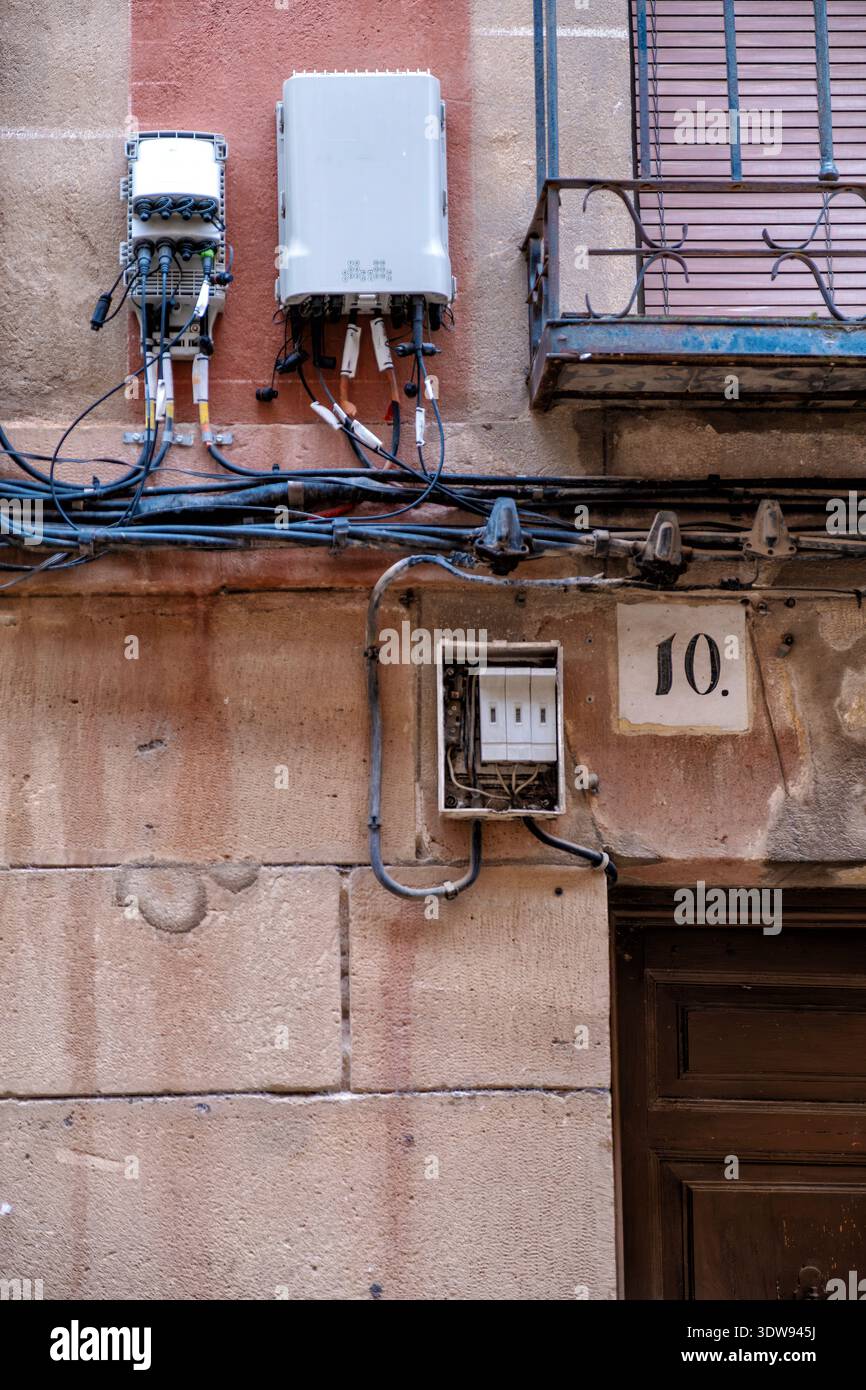 Fiber optic boxes and electrical wiring mounted on an ancient stone ...