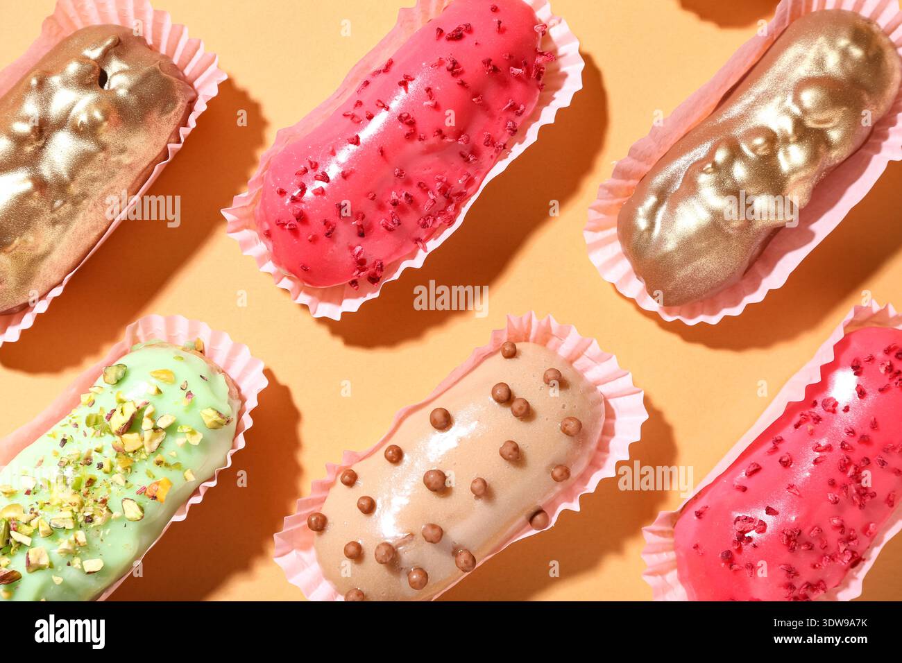 Composition with different glazed eclairs on color background Stock Photo