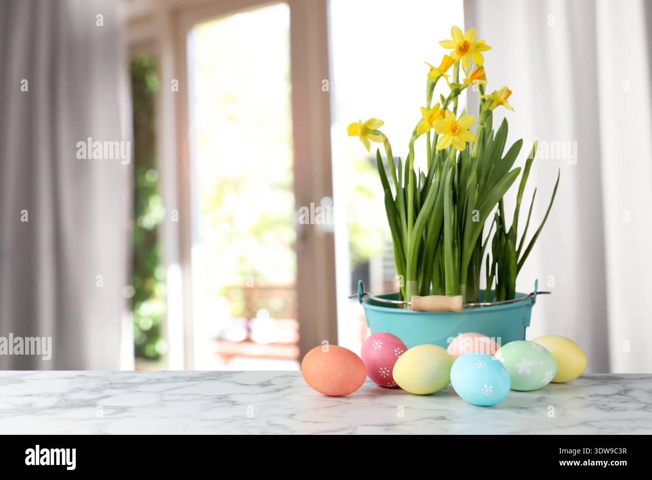 Easter eggs on table and daffodils against blurred window. Space for text Stock Photo