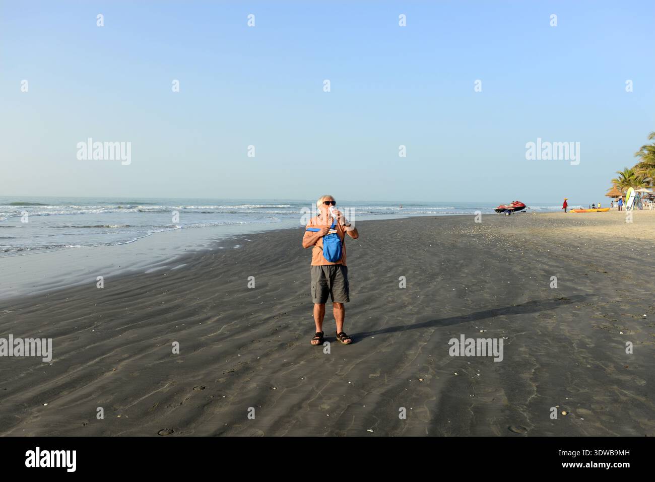 A tourist drinking beer on Serrekunda beach in The Gambia. Stock Photo
