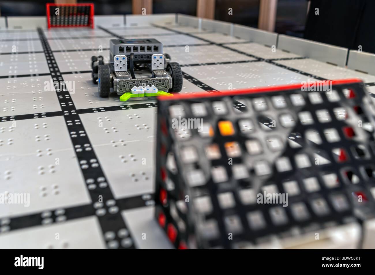 Small robots compete in a technology display at a robotics event in a classroom setting Stock Photo