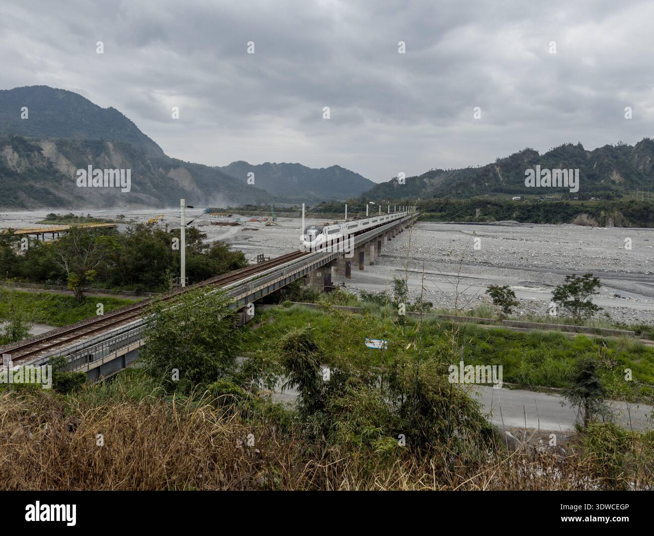 Taiwan Railway (TR) EMU3000 series Tze-Chiang, aka Tzu-chiang, Limited Express ED3181 train rear car passing by the Coastal Range (L) and Luye River a - Smartphone Captured Stock Image