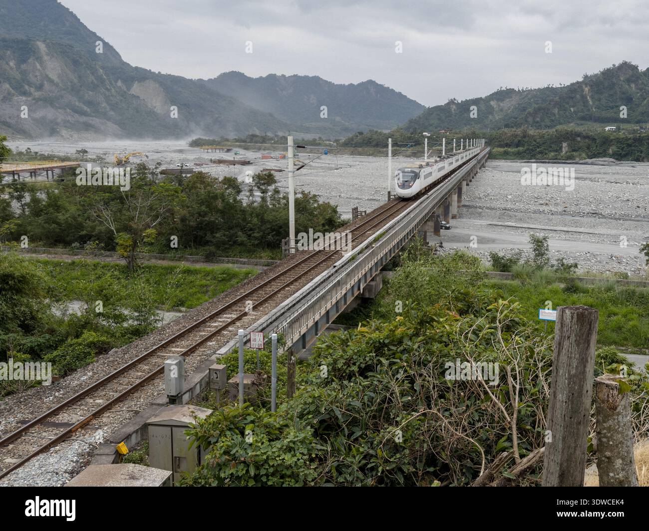 Taiwan Railway (TR) EMU3000 series Tze-Chiang, aka Tzu-chiang, Limited Express ED3101 train rear car passing by the Coastal Range (L) and Luye River a - Smartphone Captured Stock Image