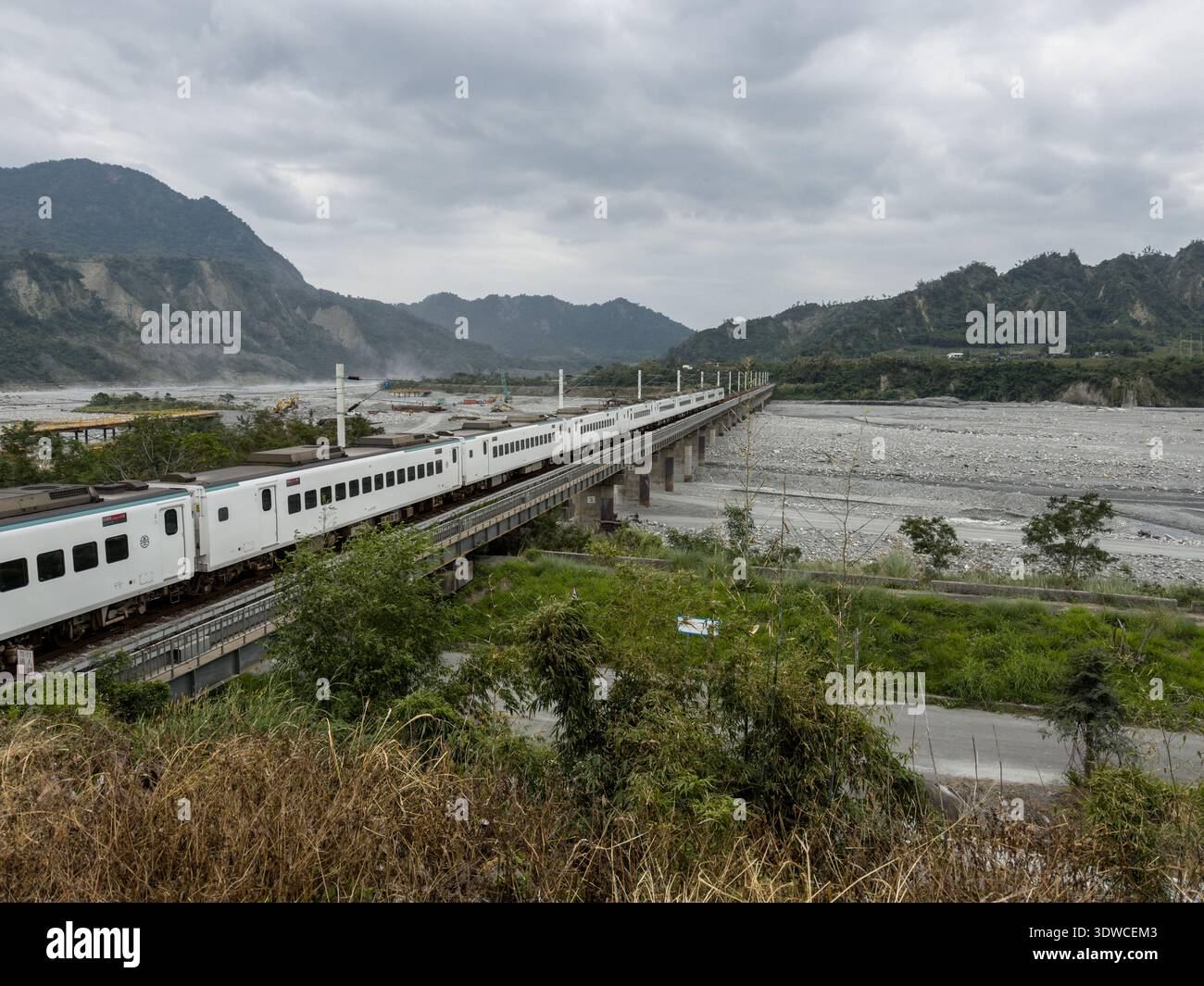 Taiwan Railway (TR) EMU3000 series Tze-Chiang, aka Tzu-chiang, Limited Express ED3181 train front car passing by the Coastal Range (L) and Luye River - Smartphone Captured Stock Image