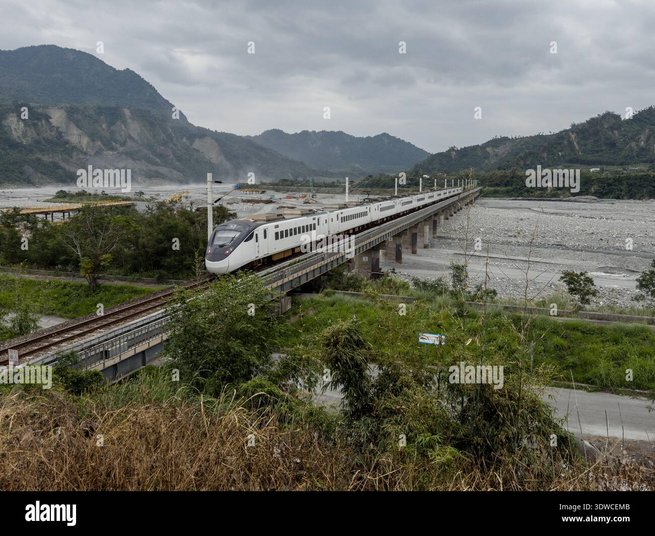 Taiwan Railway (TR) EMU3000 series Tze-Chiang, aka Tzu-chiang, Limited Express ED3181 train rear car passing by the Coastal Range (L) and Luye River a - Smartphone Captured Stock Image