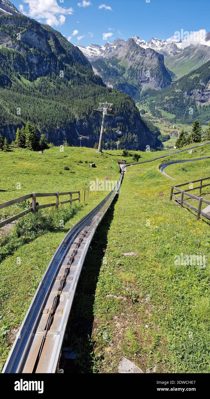 Alpine mountain coaster track with gondola in scenic valley Stock Photo ...