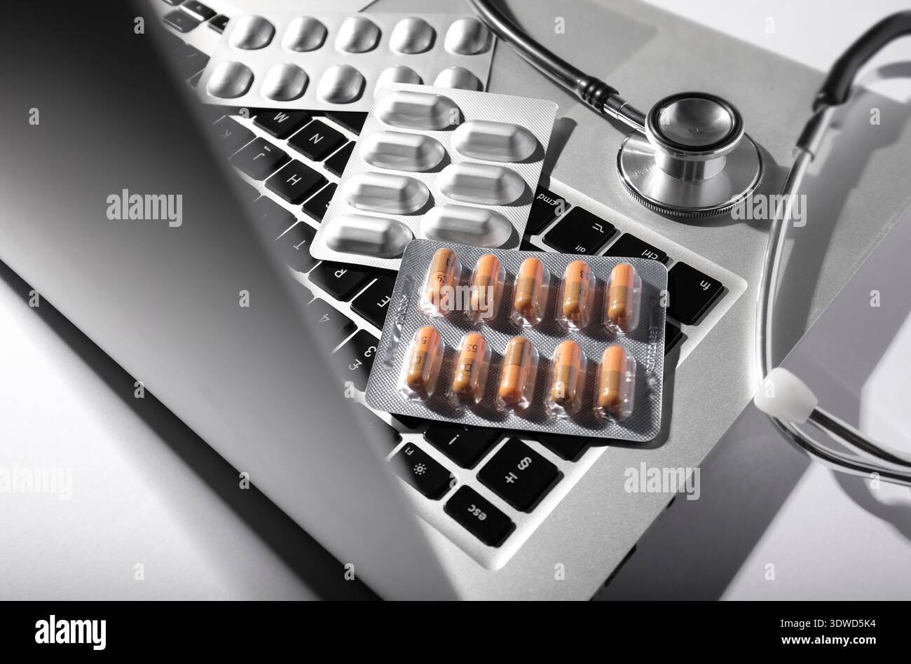 doctor's laptop computer keyboard with tablets and stethoscope Stock Photo