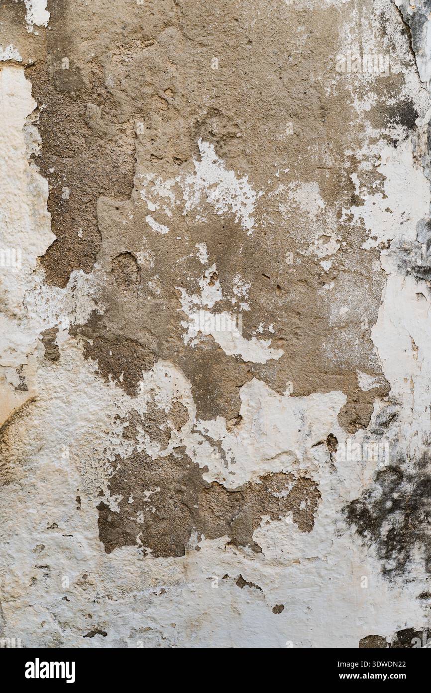 texture of an old wall with partially peeling white plaster Stock Photo